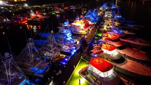 Eine Marina bei Nacht mit vertäuten Booten, beleuchtet durch farbenfrohe Lichter.