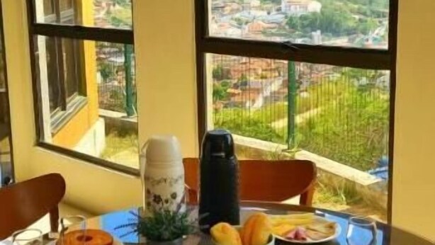 Ein Frühstückstisch mit Blick auf eine Stadtlandschaft durch große Fenster.