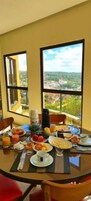 Una mesa de desayuno con vistas a un paisaje urbano a través de grandes ventanales.