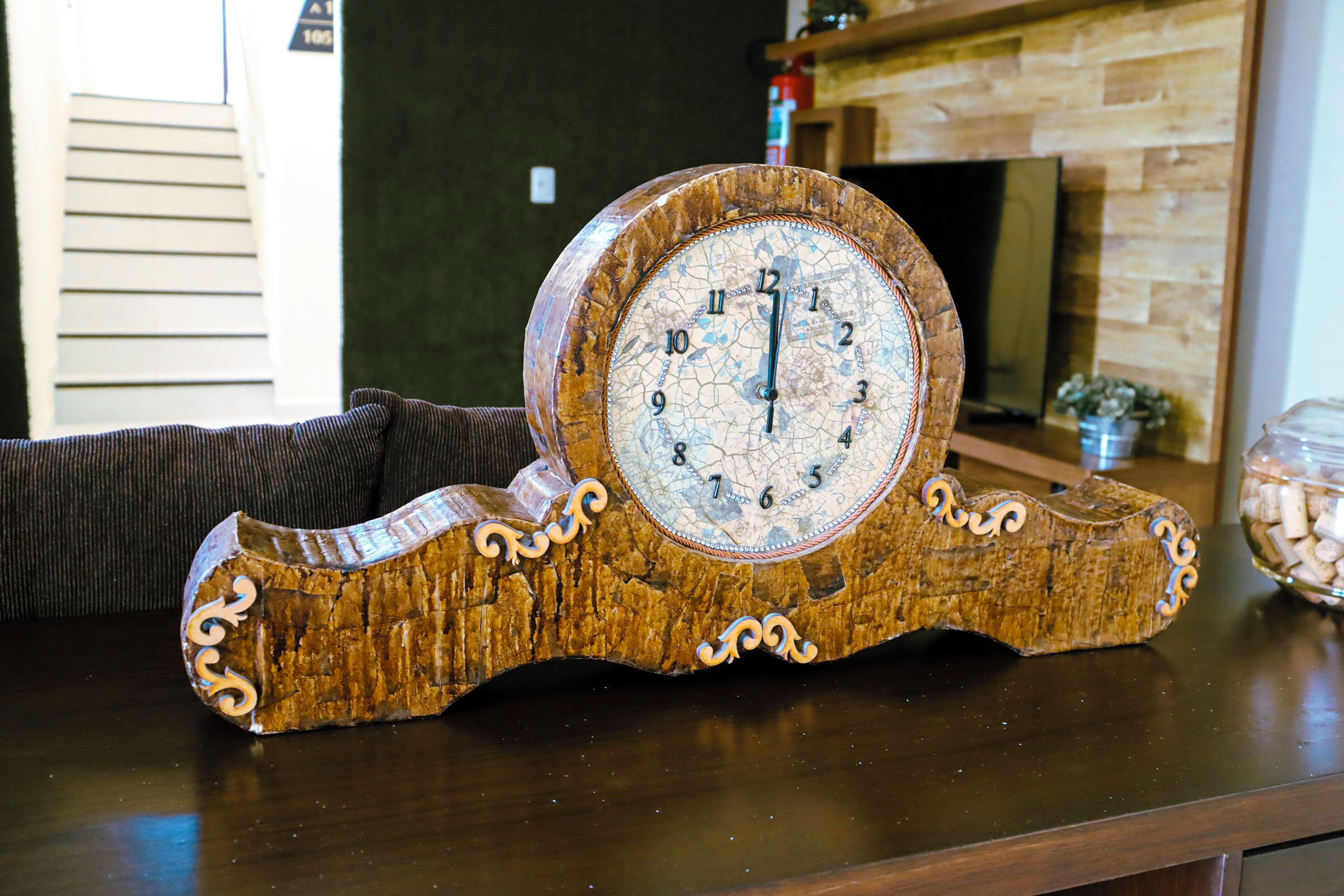 Un reloj de madera con la esfera agrietada sobre una mesa de madera.