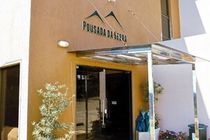 La entrada de un edificio con un letrero que dice "Pousada da Serra".