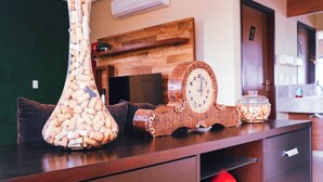Ein Holztisch mit einer Vase voller Weinkorken, einer Dekotasse und einem Glas.