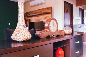 Una mesa de madera con un jarrón de tapones de vino, un reloj decorativo y un frasco de vidrio.