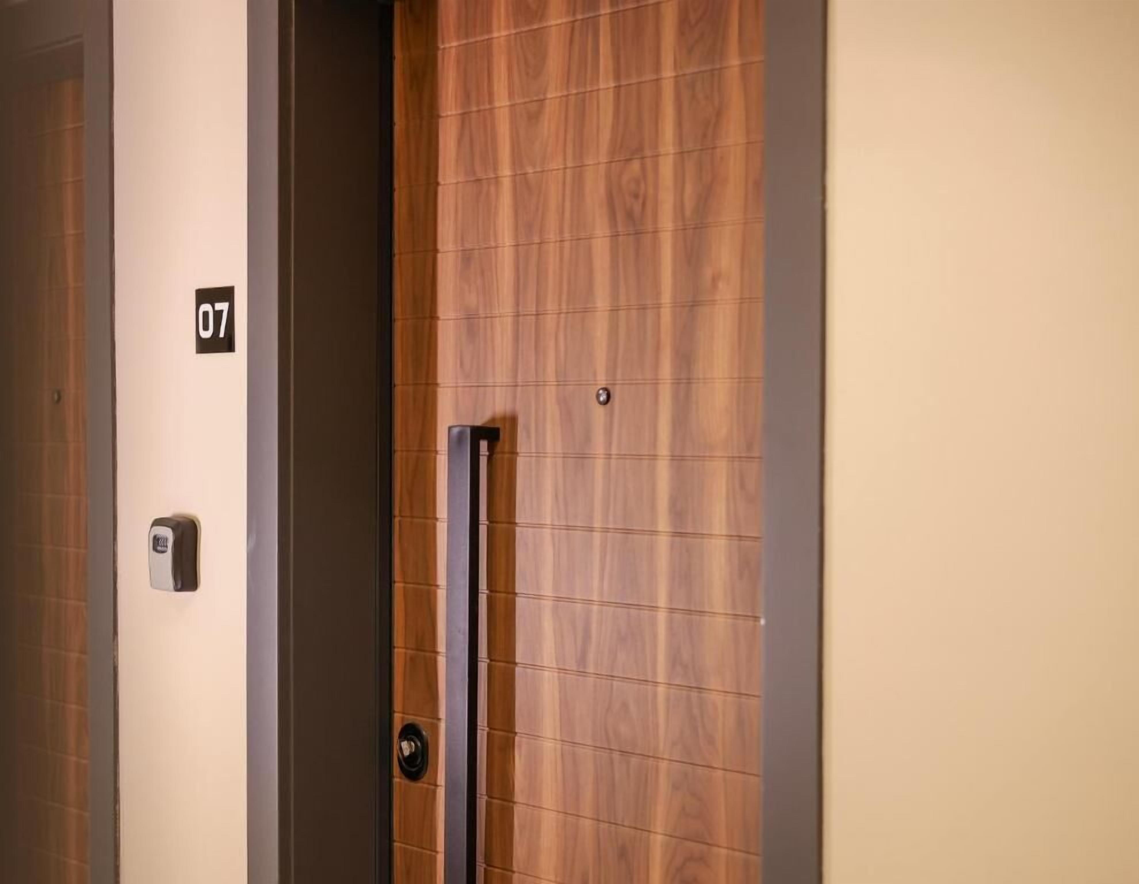 A hotel room door with a wooden panel design and a number sign indicating room 07.