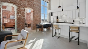 Una cocina moderna con armarios blancos, una isla grande e iluminación colgante.