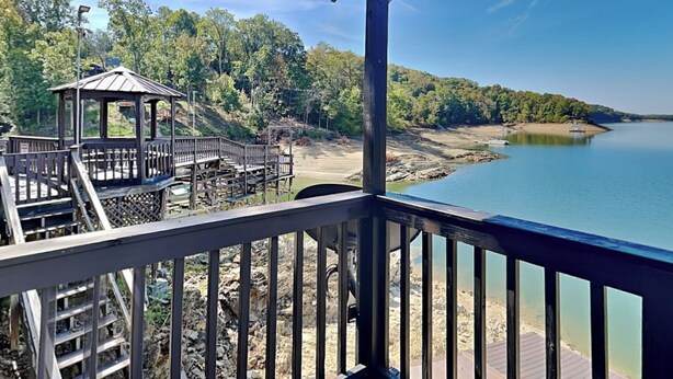 A wooden deck with a gazebo overlooking a calm lake, surrounded by trees. - Reel It In | Epic Views, Dock & Pier, Game Room (Dandridge)