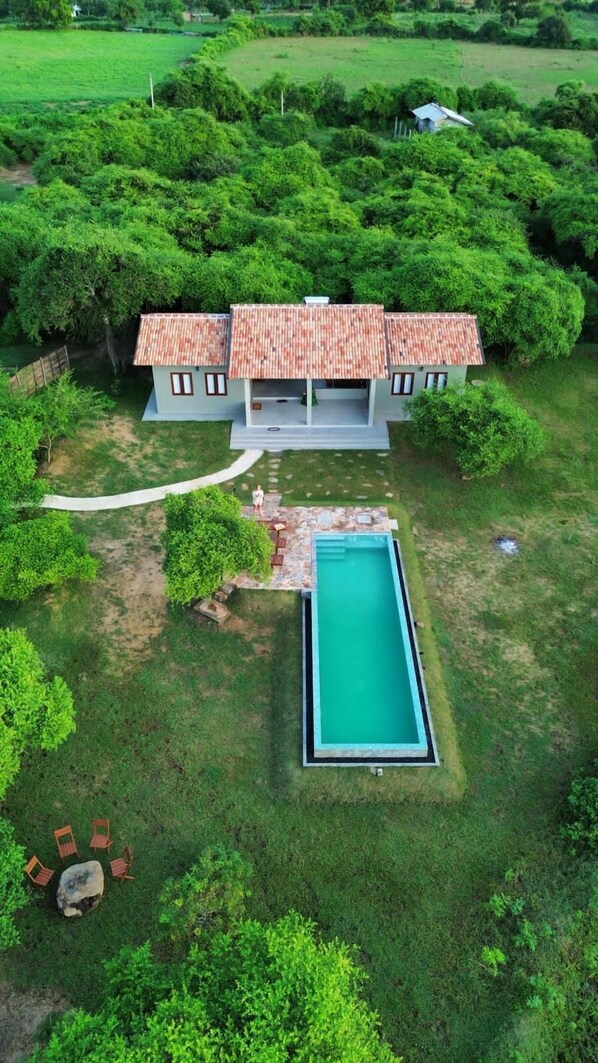 Ein Haus mit Schwimmbad, umgeben von üppigem Grün.