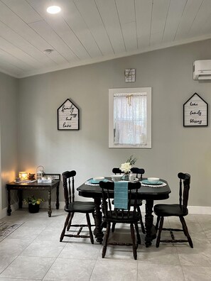 A dining area with a round table, four chairs, and a small side table with a lamp. - 2/2 Secluded Home In Bastrop! 2mins from downtown 2mins From Bastrop Lake (Bastrop)