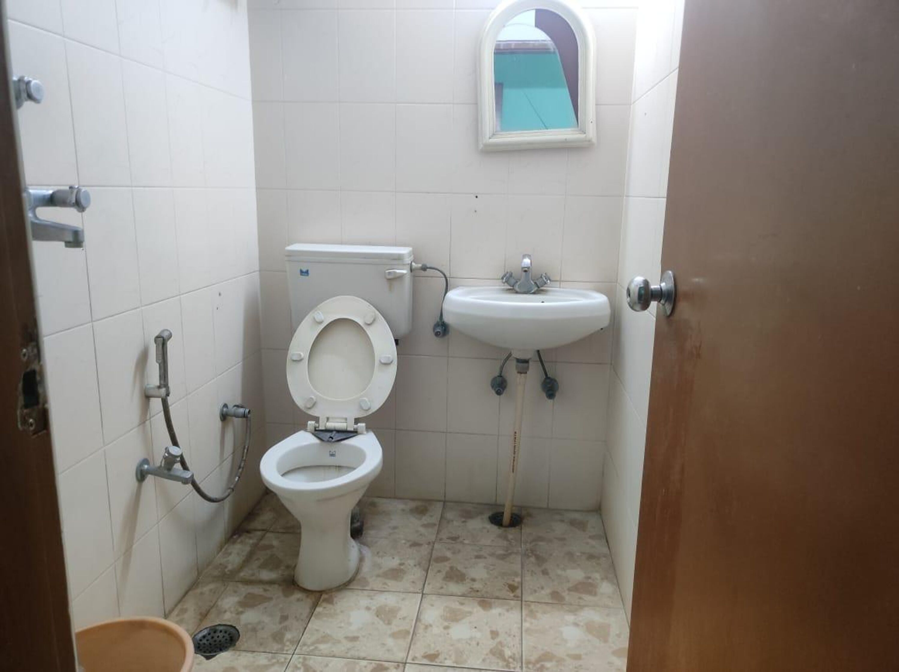 Une petite salle de bain avec des toilettes, un lavabo et un miroir.