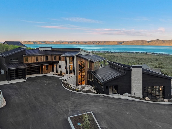 A modern building with a garage, a staircase, and a view of a lake.
