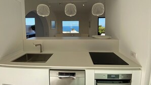 Una cucina moderna con forno integrato, lavastoviglie e un'ampia finestra vista mare.