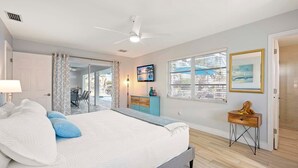 A bedroom with a bed, a ceiling fan, a TV, and a window with blinds. - Allure - Luxury Rental in Walking Distance to Cape Coral Yacht Club (Cape Coral)