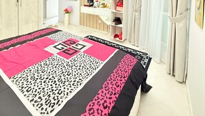 Une chambre à coucher comprenant un lit, une armoire, une coiffeuse et un miroir.