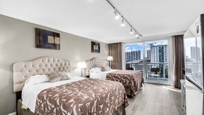 Een moderne hotelkamer met twee bedden, een balkon en uitzicht over de stad, plus een groot raam.