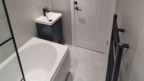 Un baño moderno con una bañera, un lavabo y una puerta.