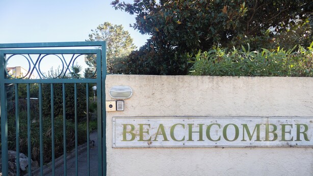 Um portão com uma placa indicando 'BEACHCOMBER'.