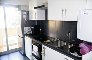 Eine kleine Küche mit Geschirrspüler, Backofen und Spüle.