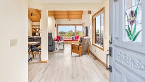 A spacious living area with a wooden ceiling, a dining table, and a sofa with red cushions. - Pacific FantaSea - Sea Ranch 2BR+Loft, Hot Tub, 6 (Sea Ranch)