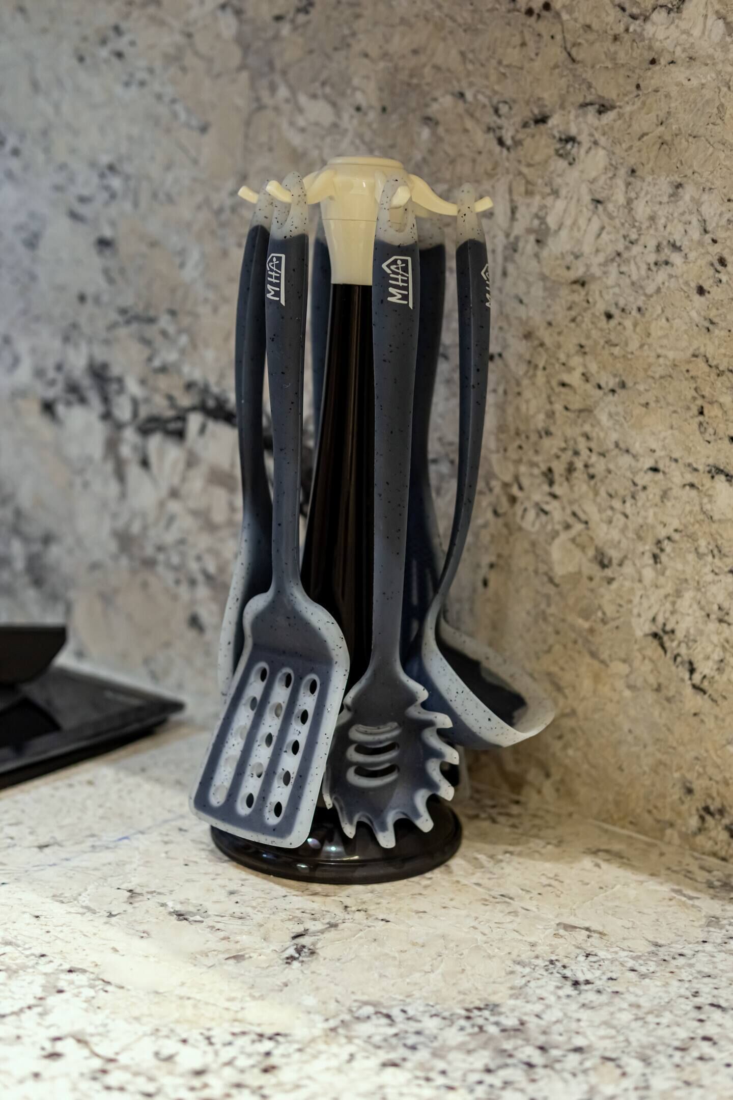Un recipiente para utensilios de cocina con varios utensilios.