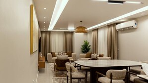 A modern conference room with a round table, comfortable seating, and a large window with curtains. - Entire rental unit in Al Manteqah Ath Thamenah, Egypt (Cairo Governorate)