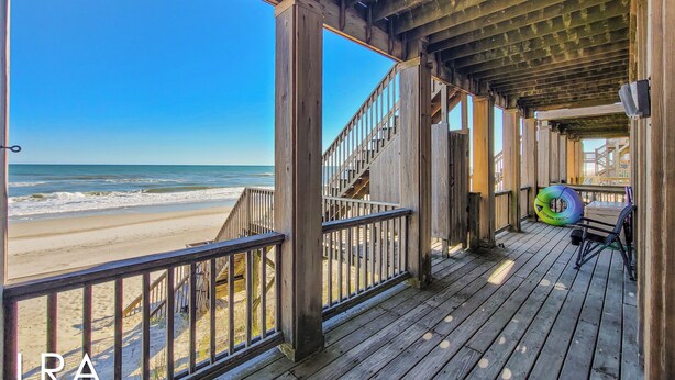 A wooden deck with a view of the beach and ocean. - Inn Luxury North | Livin’ the Luxe Life (Surf City)
