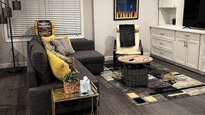 Una sala de estar moderna con un sofá, una mesa de centro y un televisor.