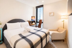 A hotel room with a bed, a desk, a chair, a lamp, and a window with a view. - Artsy 2BR 2BA Retreat in West Village, West End Brisbane (West End)