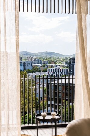 Un balcón con vistas a un paisaje urbano, que incluye edificios y una colina.