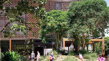 A courtyard with a traditional tiled wall, stone steps, and lush greenery.