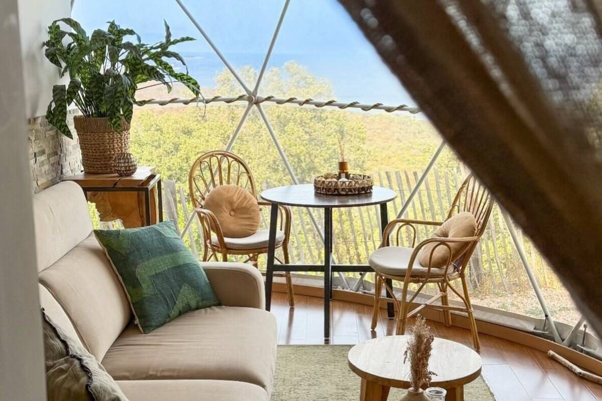 An indoor seating area with a view of a mountainous landscape.