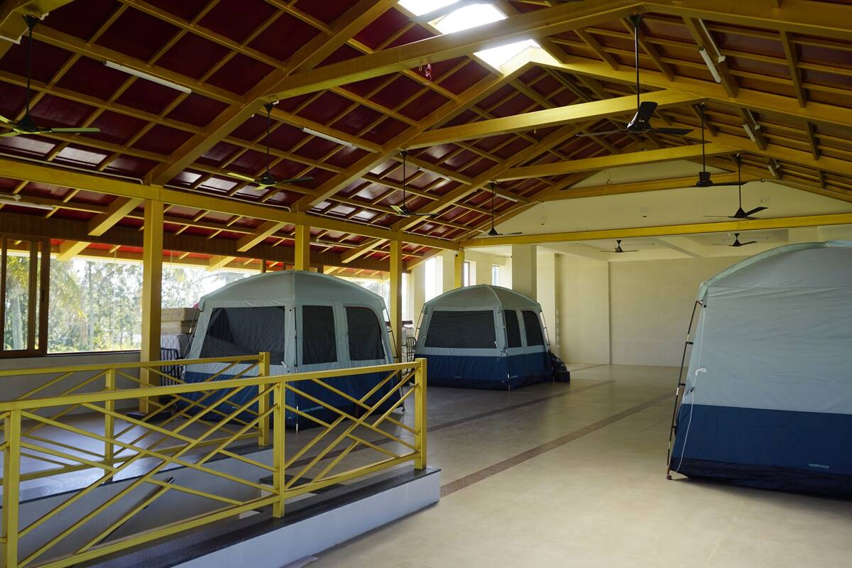 A covered outdoor area with two tents and a yellow railing.