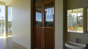 A room with a wooden door, a large window, and a sink. - AT CKM Homestay (Chikkamagaluru)