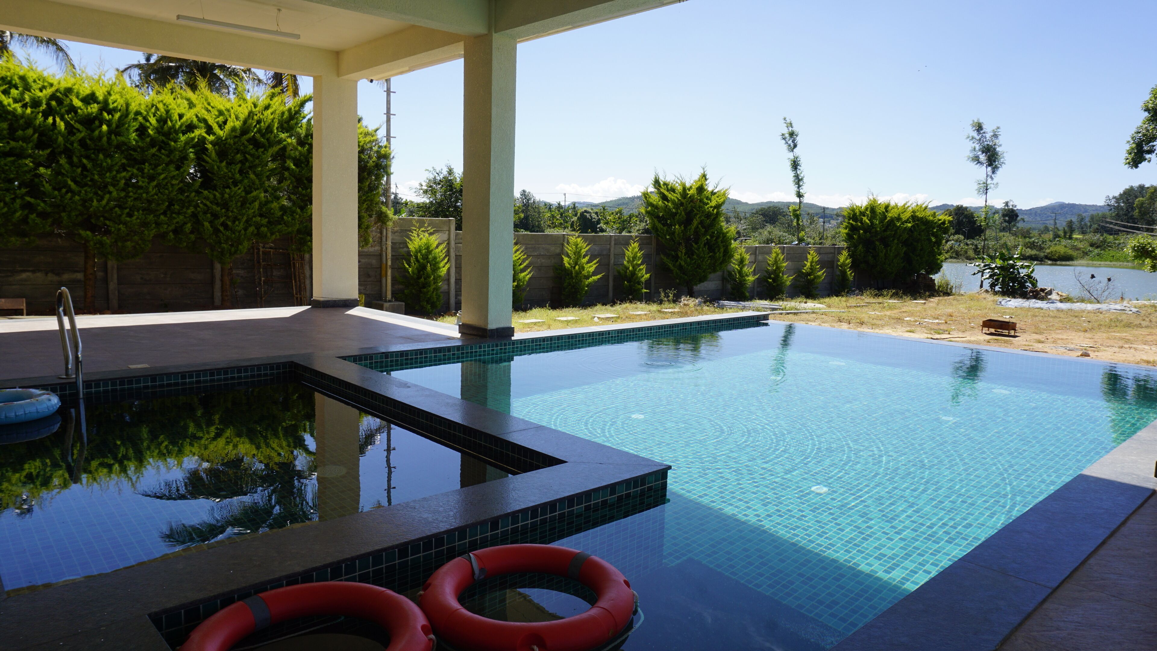 Une piscine avec vue sur un lac et des montagnes en arrière-plan.