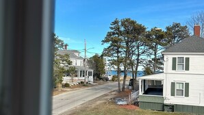 A residential street with houses, a clear sky, and a view through a window. - Wonderful 4-bedroom apartment with AC in peaceful Saco (Saco)