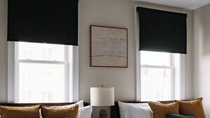 Ett hotellrum med två sängar, en golvlampa och en takfläkt.