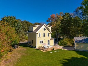 A two-story house with a front porch and a small patio area.