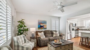 A modern living room with a sofa, armchair, coffee table, and a painting on the wall. - Bay Ridge House- Charming 2-Bedroom Home – Large Backyard, Family-Friendly, Clos (Annapolis)