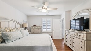 A bedroom with a bed, dresser, television, ceiling fan, and a door. - Bay Ridge House- Charming 2-Bedroom Home – Large Backyard, Family-Friendly, Clos (Annapolis)