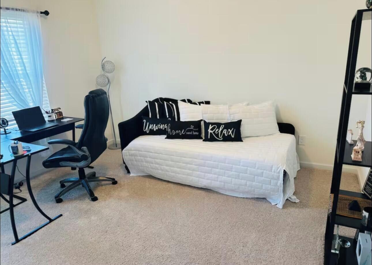 Una camera da letto con un letto, una scrivania e una sedia.