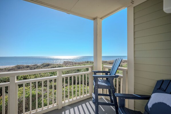 A balcony with a view of the ocean and beach. - Sunset Haven: Beautiful, Caswell Beach, Oceanfront Condo (Caswell Beach)