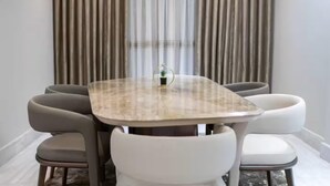 A round table with a marble top surrounded by four chairs. - 3-bedroom apartment in enchanting Cairo Governorate with AC (Cairo Governorate)