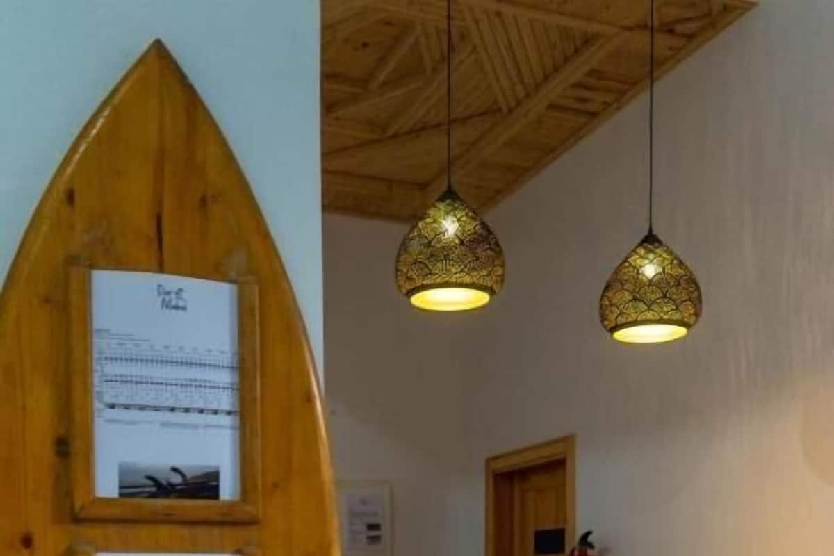 Un mostrador de recepción con un fondo de madera y carteles informativos enmarcados.