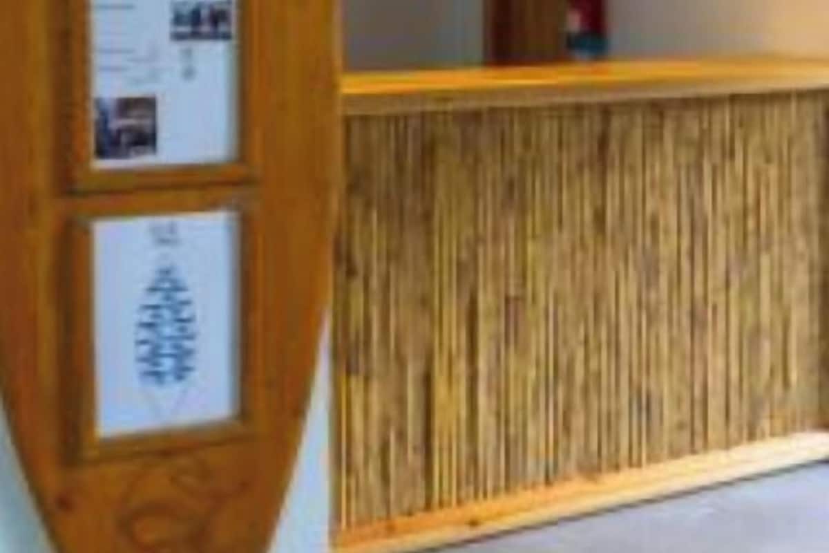 Un área de recepción con un mostrador de madera, lámparas colgantes y un tablón de anuncios.