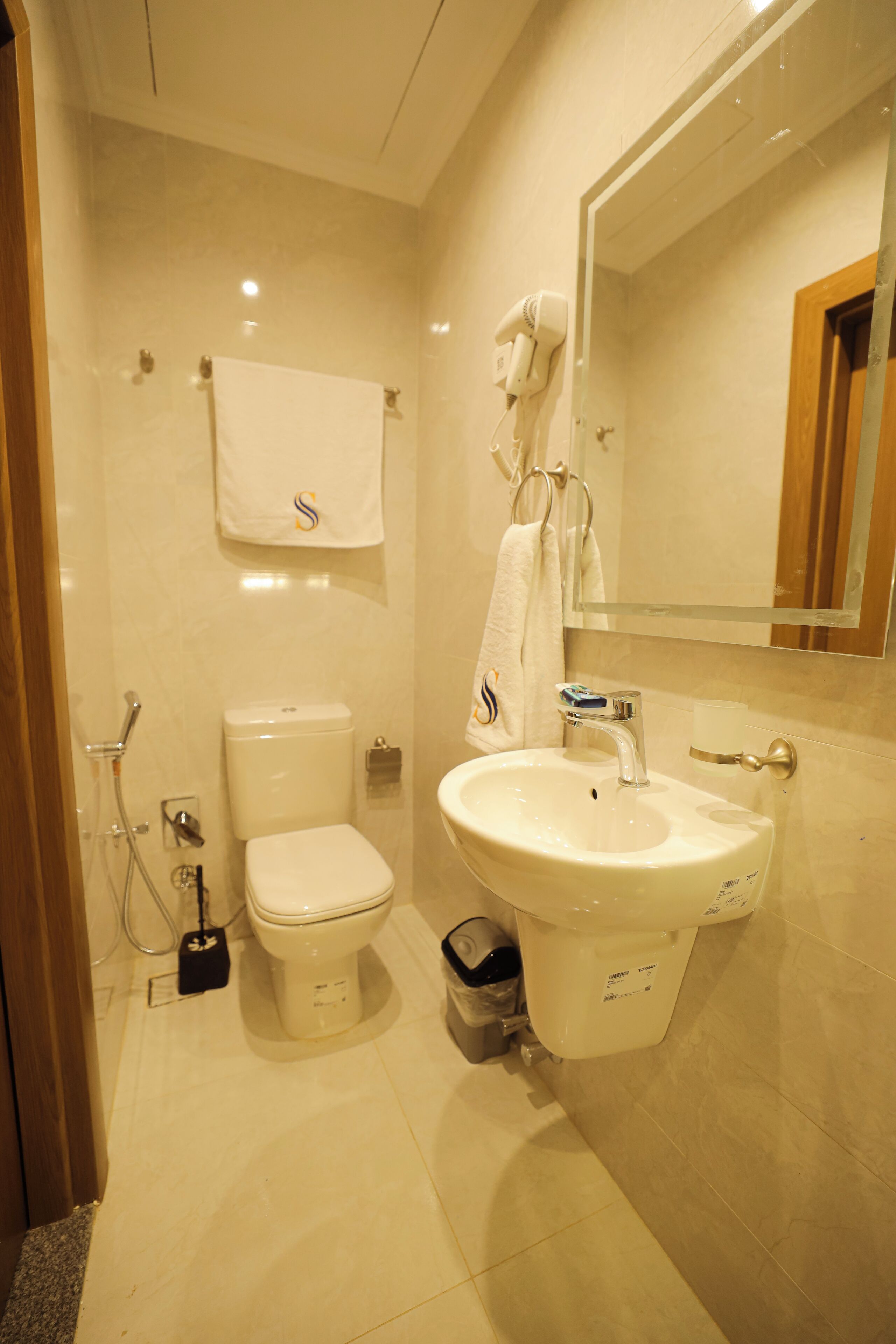 A modern bathroom with a toilet, sink, and mirror.