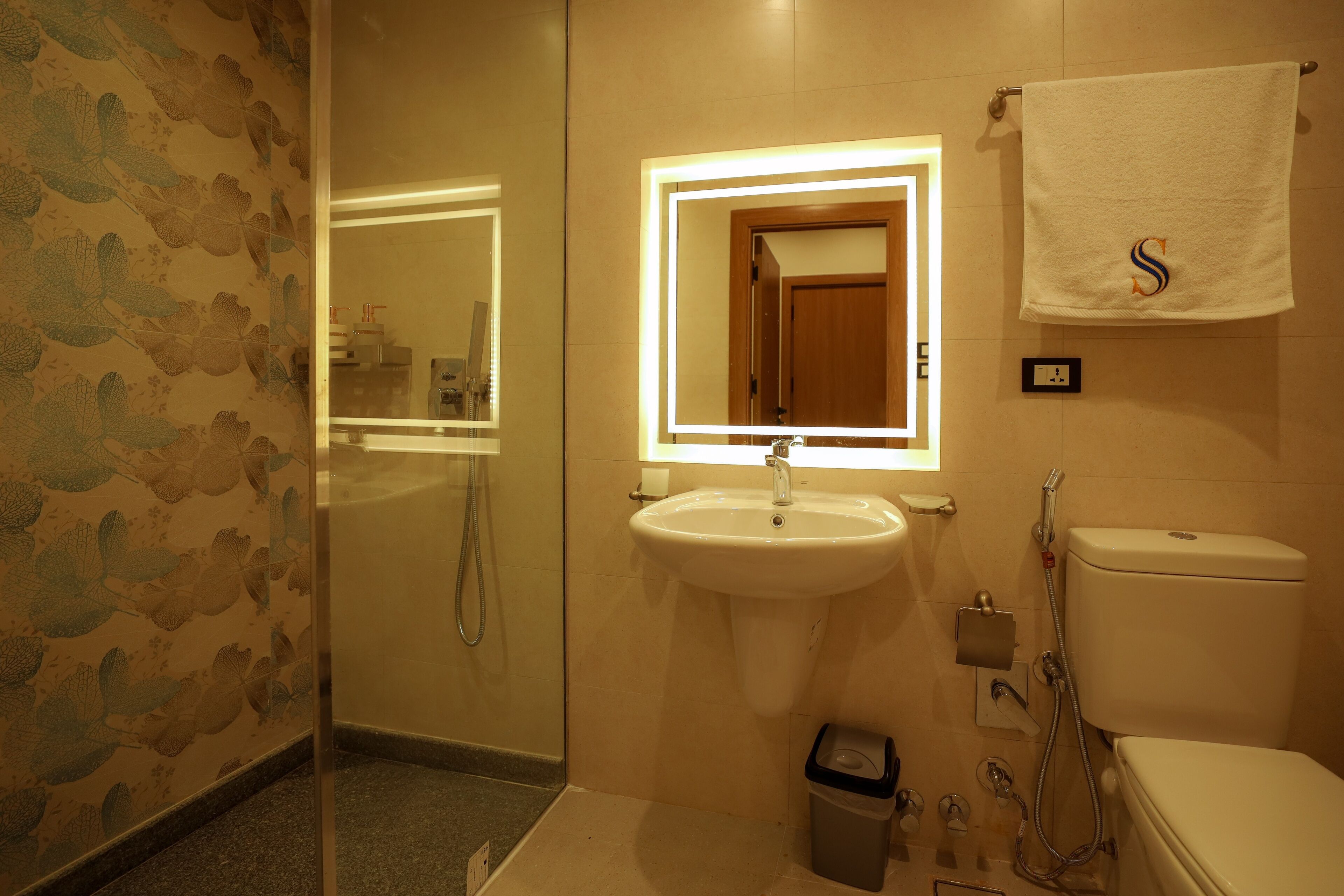 Een badkamer met een wastafel, spiegel, toilet en douche.