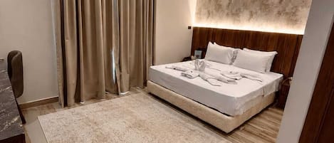 A modern bedroom with a bed, curtains, a headboard, and a rug.