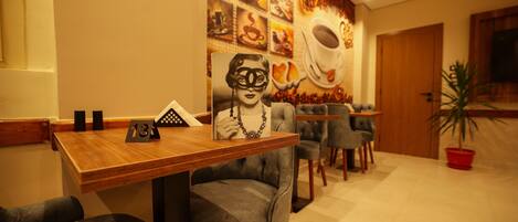 A restaurant with a wall mural of food and a table with a framed picture.