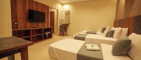 Habitación de hotel con dos camas, un televisor, un espejo y un revestimiento de pared de madera.