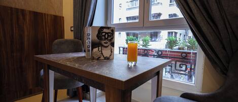 A dining area with a table, chairs, a book, and a glass of orange juice.