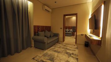 Deluxe studio suite, uitzicht op stad | Woonruimte | Een 42-inch ledtelevisie met satellietzenders en Netflix